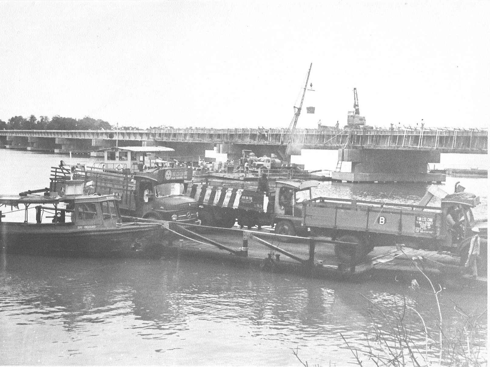 old boats sit in the water near a bridge