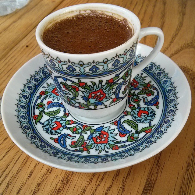 a cup of coffee with a saucer filled with  chocolate