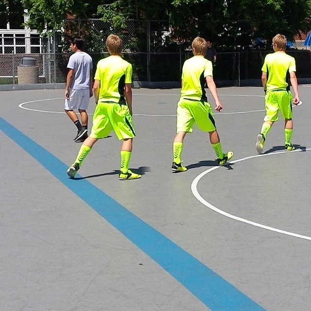some young men on a basketball court with one man in the middle playing