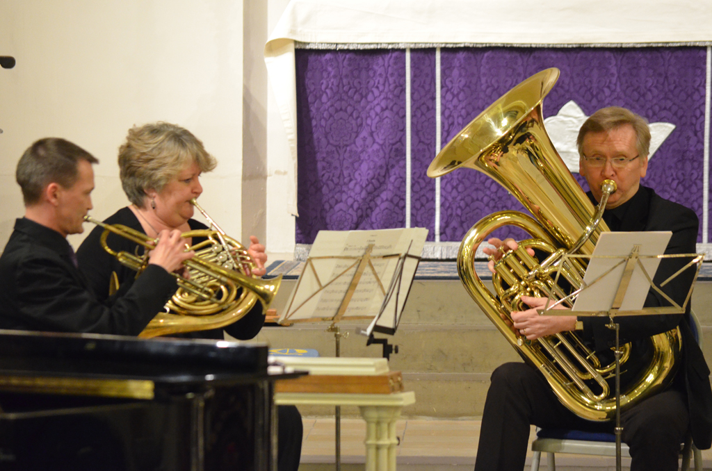 the man in black is playing his trumpet