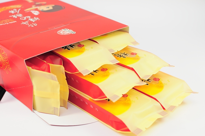 a red paper bag with four pieces of yellow food in it