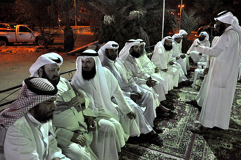 many men dressed in long, white robes sitting together
