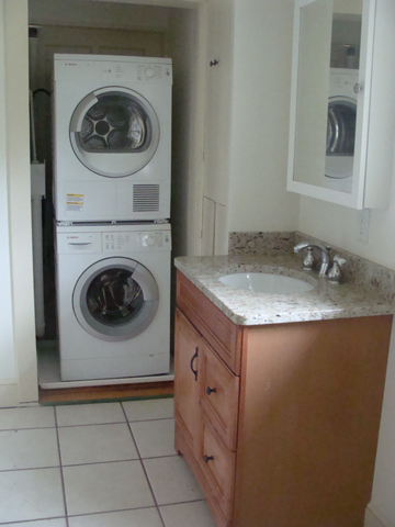 a clean bathroom with two washer dryers