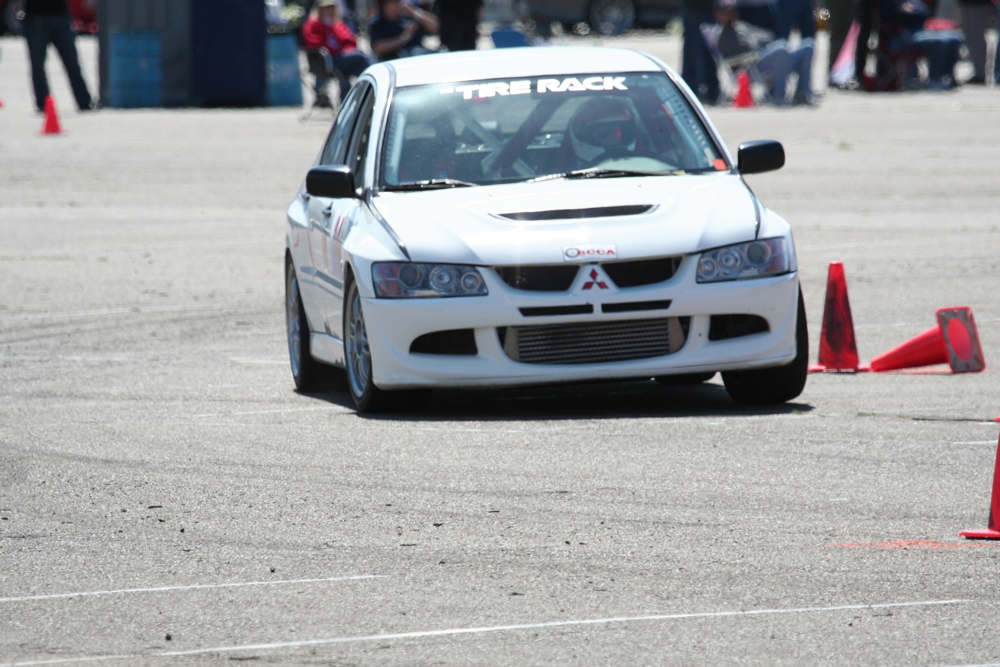 a white race car driving on top of a race course