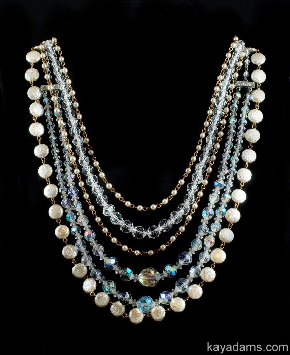 a very long multi strand necklace set with pearls