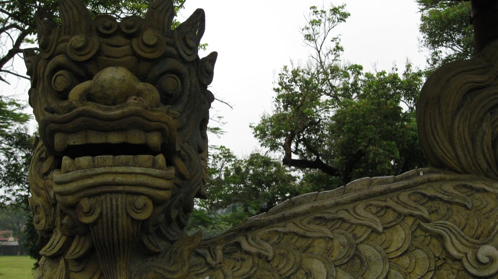 two carved stone animals on a field of green grass