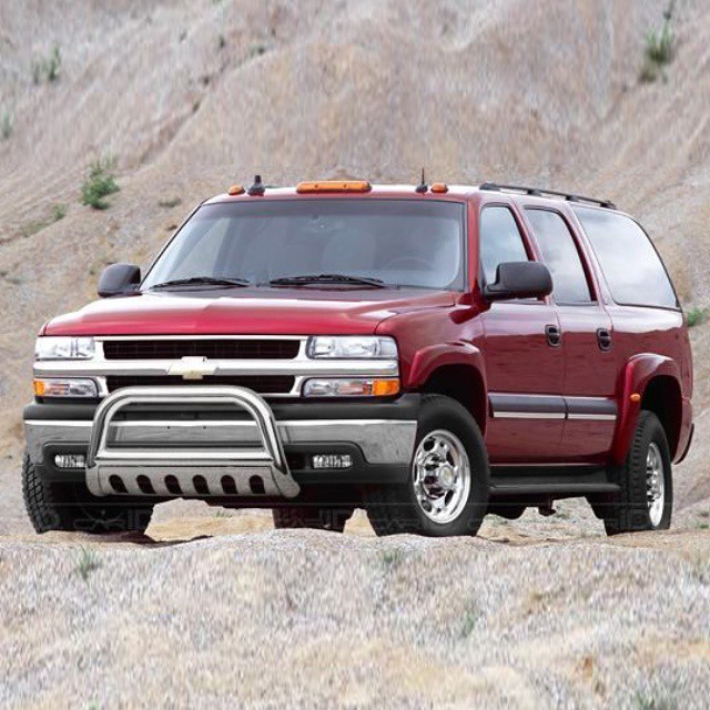 a large red chevrolet suburban is driving through the desert