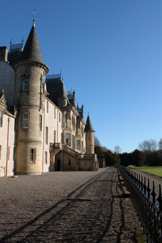a long driveway leads to the front of an old castle