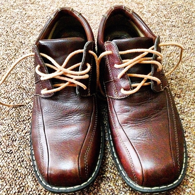 pair of brown leather shoes on carpeting area