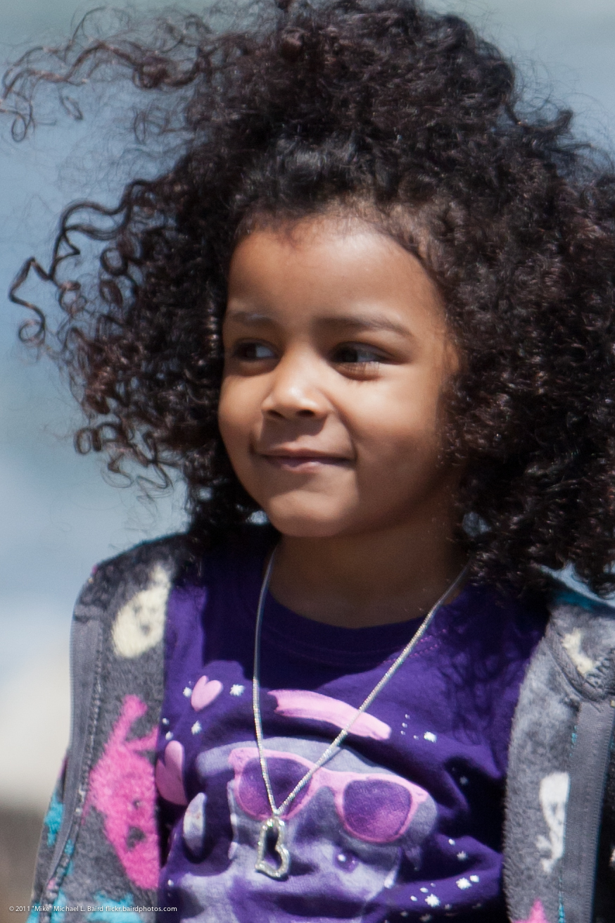 a  smiling, while wearing a purple and black shirt