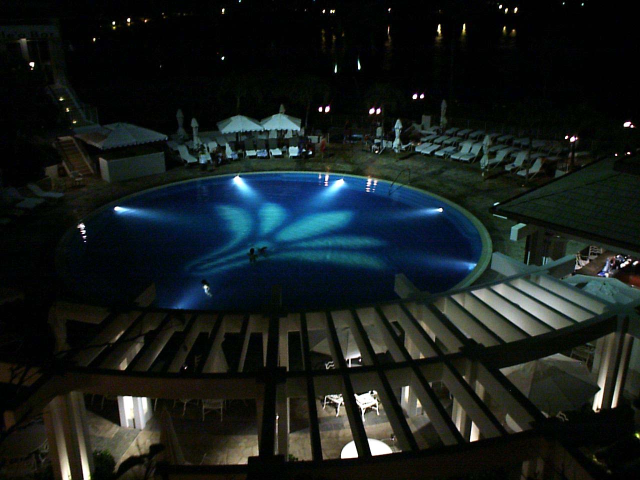 an overhead view of a pool in a resort at night