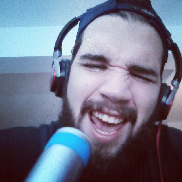 a bearded man wearing headphones and smiling