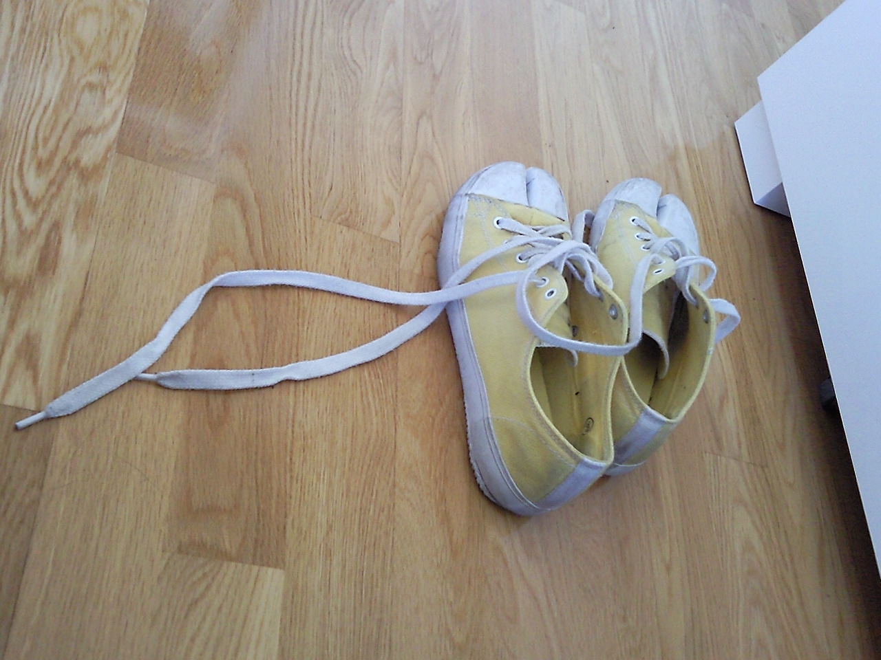 a pair of white tennis shoes that are on the floor