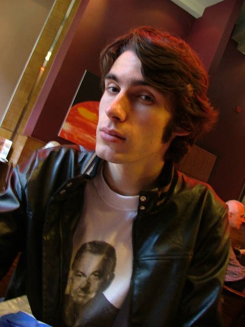 a young man wearing black jacket and white t - shirt with portrait