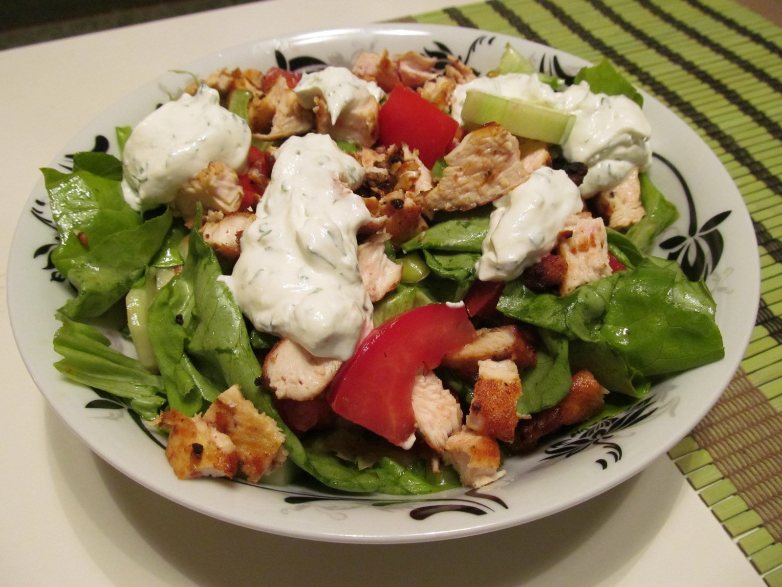 a salad that has chicken and tomatoes on it