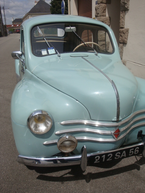an old blue car is parked in front of a building