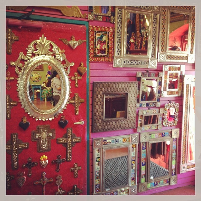 red wall covered with decorative wall mirror and other objects