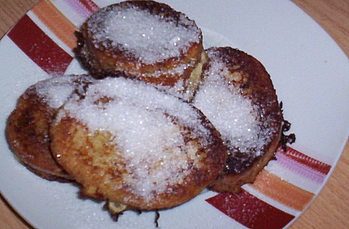 powdered pastry pastries sitting on a white plate