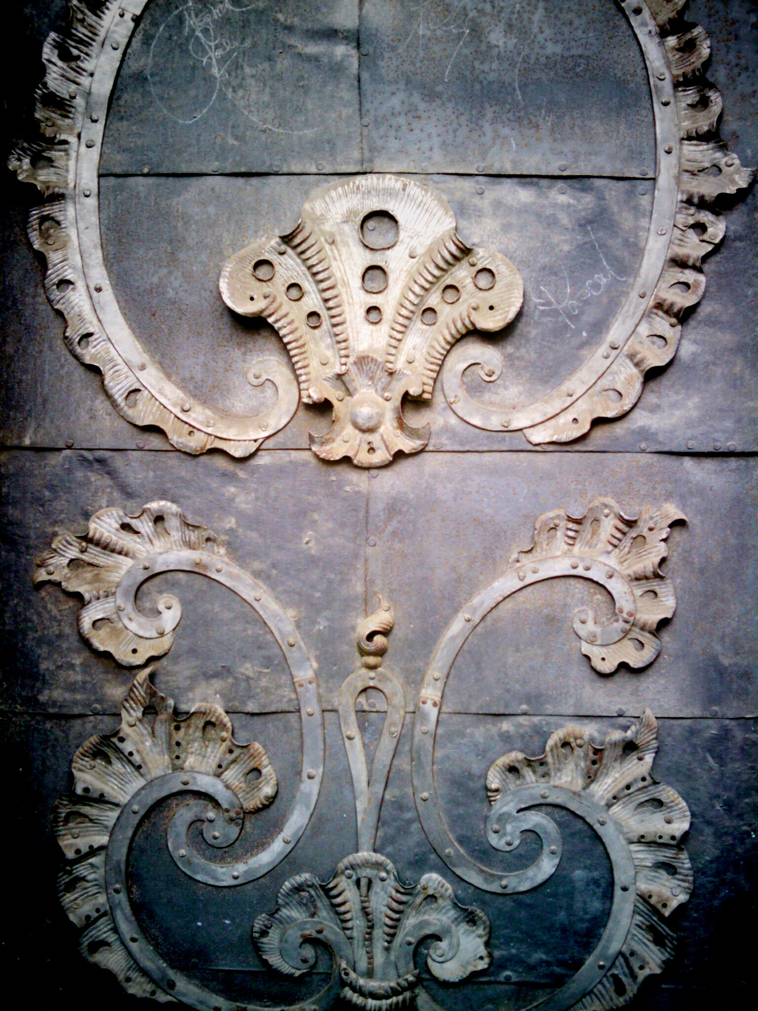 an antique cast iron wall with vines and scrolls