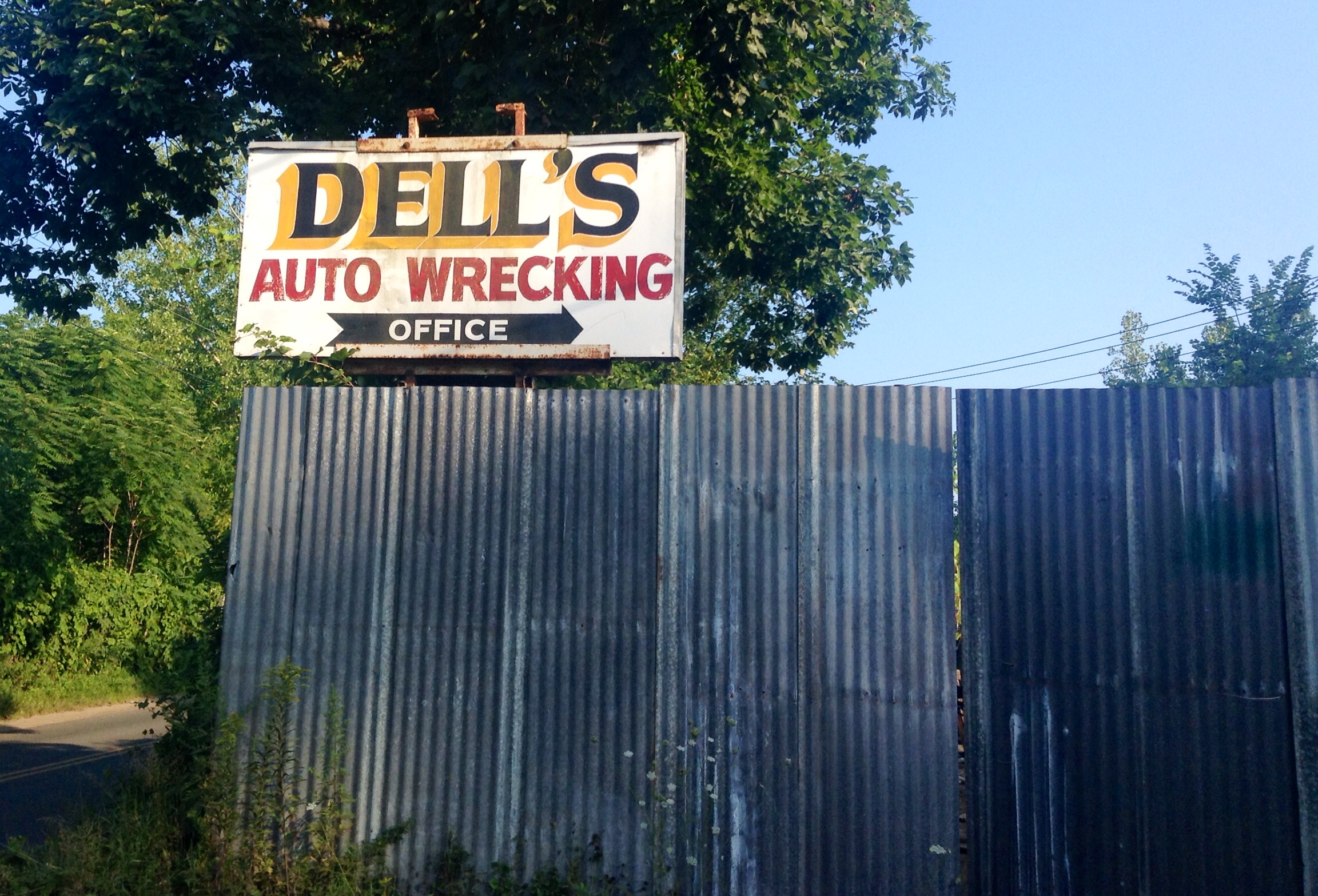 a sign advertising a repair shop and auto wrecking office