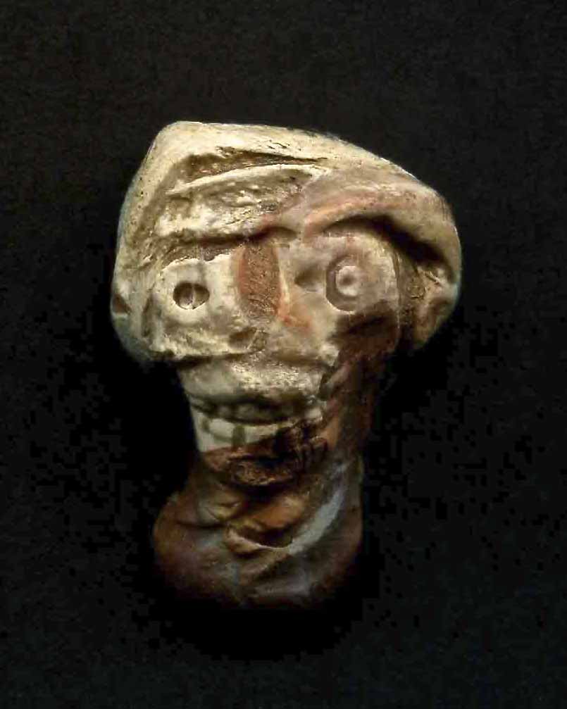 a stone sculpture of a face with a strange look on it's head