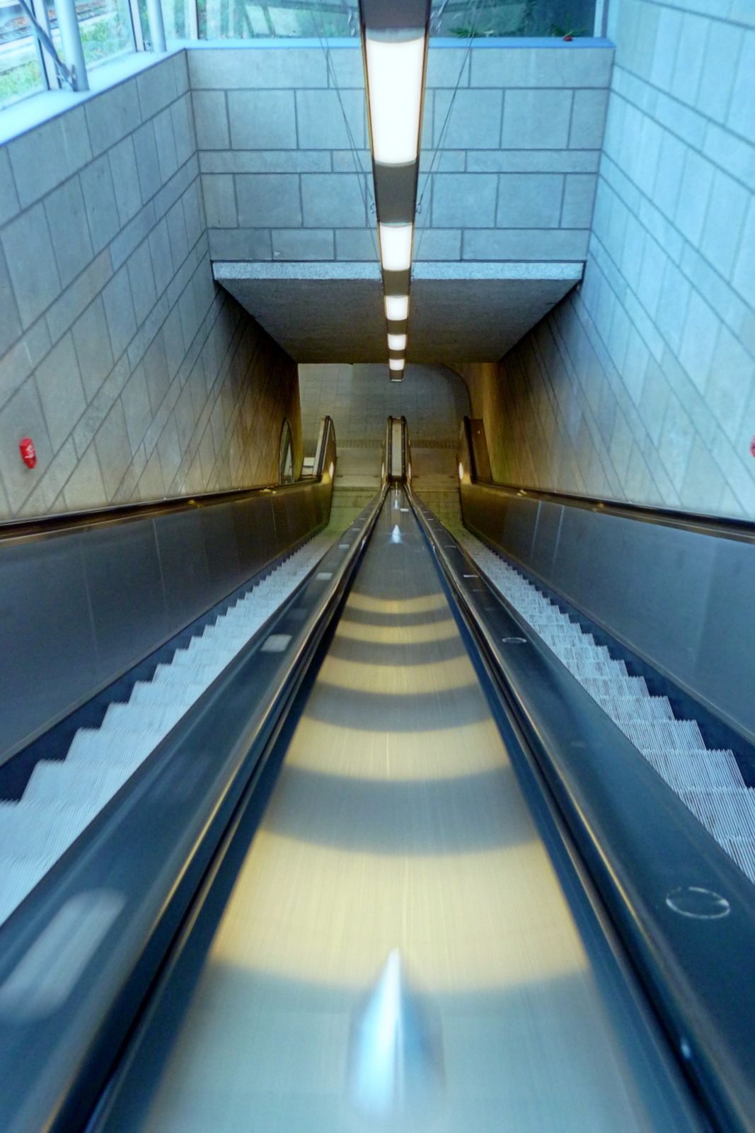 a person riding down a very long moving escalator