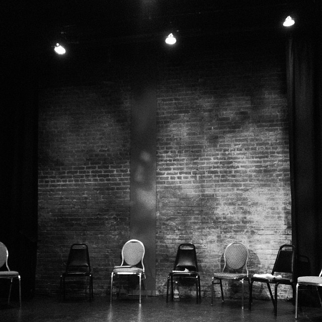 a set of six chairs next to a brick wall