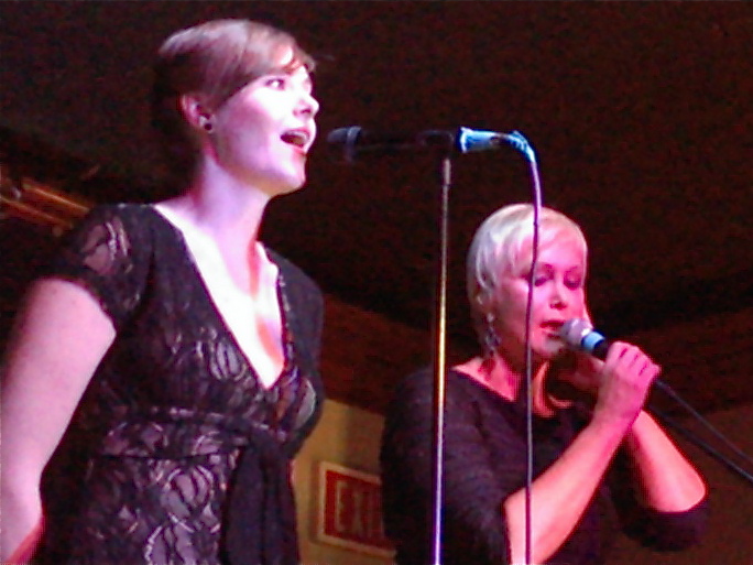 a close up of two people on a stage singing