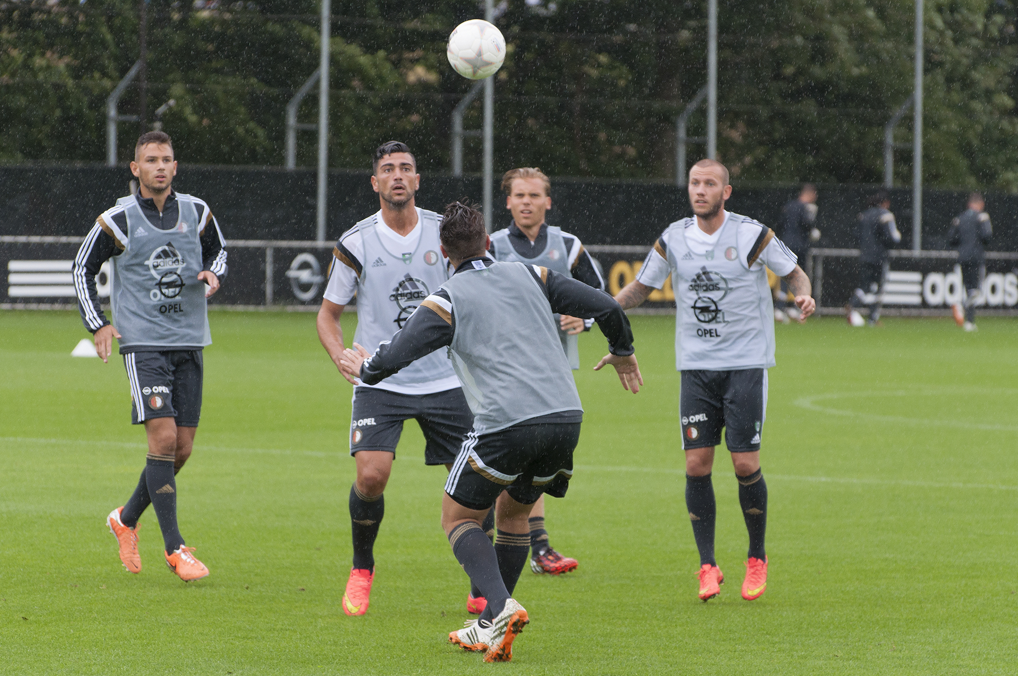 four men play soccer in front of an open field