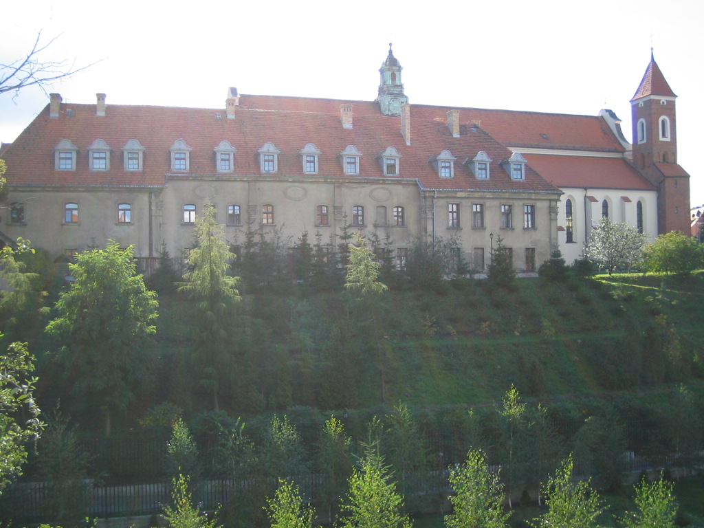 a large house surrounded by a green forest