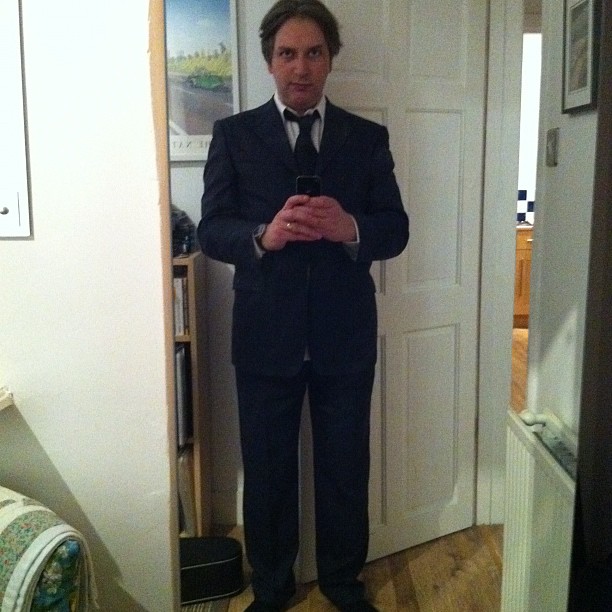 a man in a suit standing in a doorway