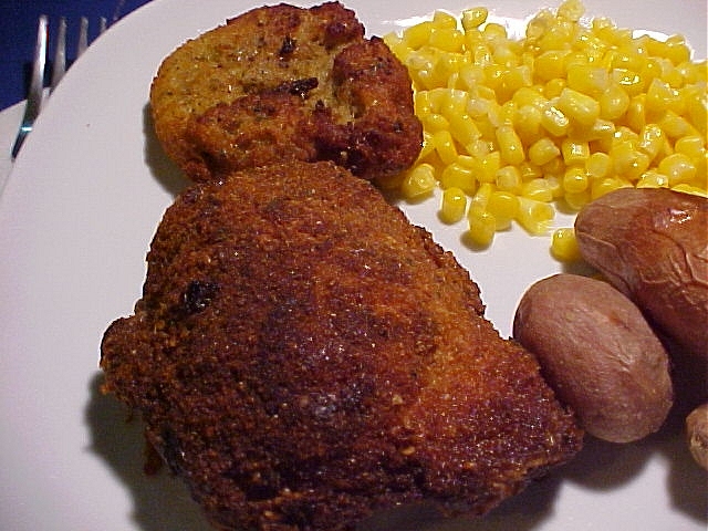 chicken strips, corn and potatoes are sitting on a plate
