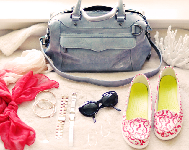 a woman's purse, sunglasses, and other accessories laid out on the table