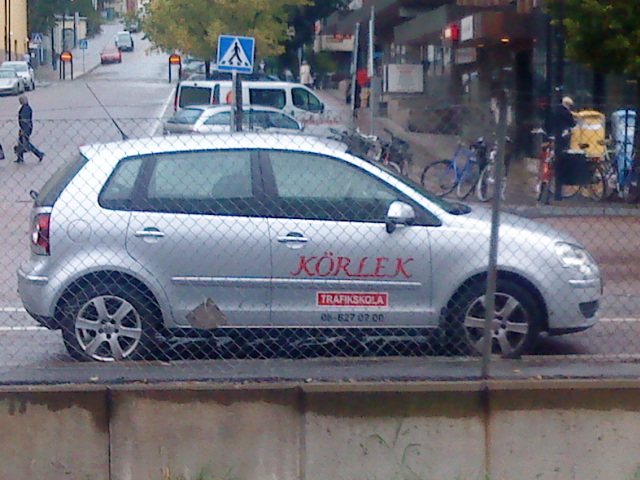 an image of a small silver car that is parked in the street
