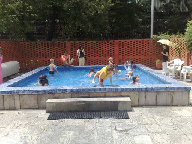 a swimming pool filled with children and adults