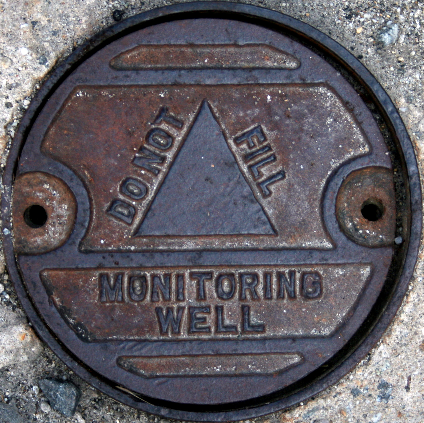 a close up of a manhole cover with symbols on it