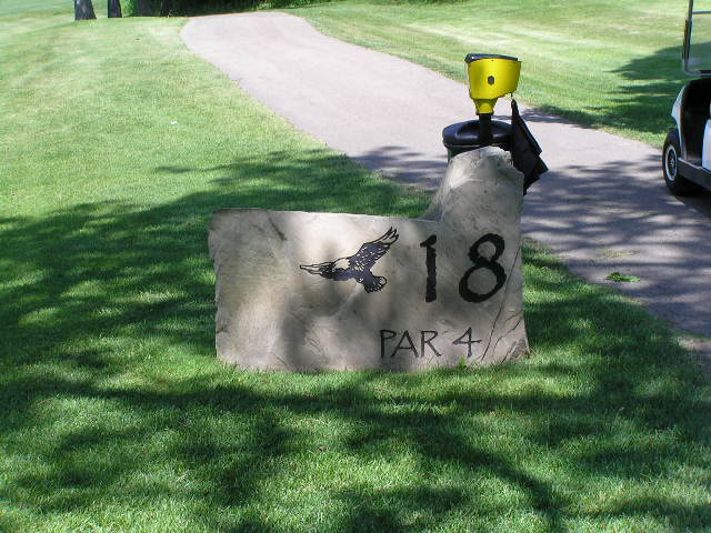a stone sign with an eagle and a candle holder