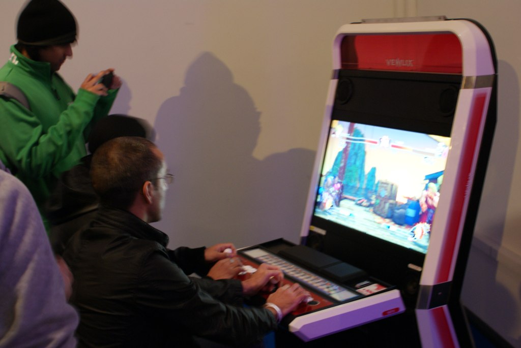three people play a video game with colorful screens