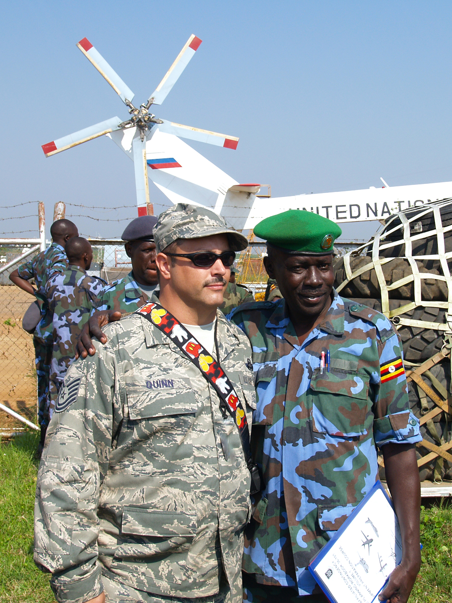 two men in camouflage uniform pose for a po