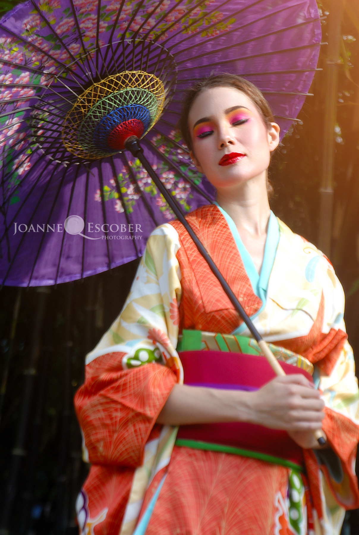 a geisha girl poses for a pograph while holding an umbrella