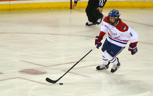 a hockey player moving after a stick with one leg on the ice