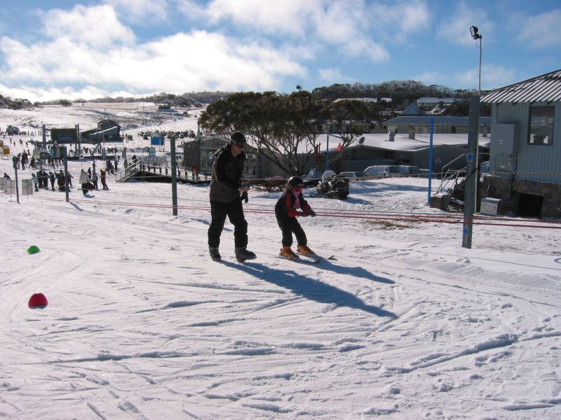 the man and small child are standing in the snow