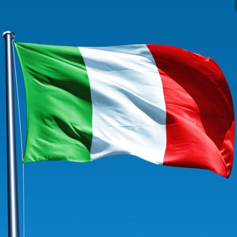 the flag of italy on a pole with a blue sky behind it