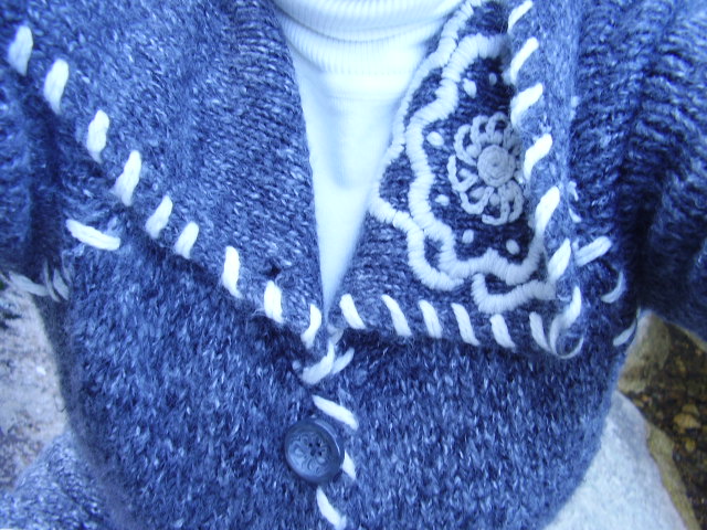 a close up s of a blue knitted jacket with stripes