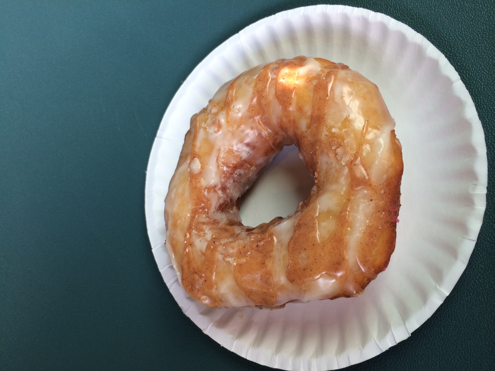 a doughnut sitting on a plate, ready to be eaten