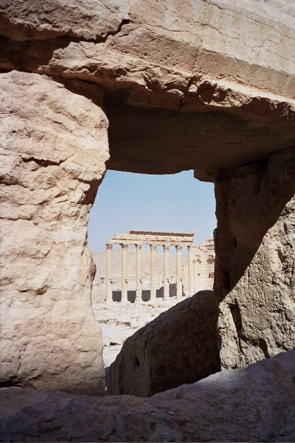 a picture from behind of a rock with a building and an arch