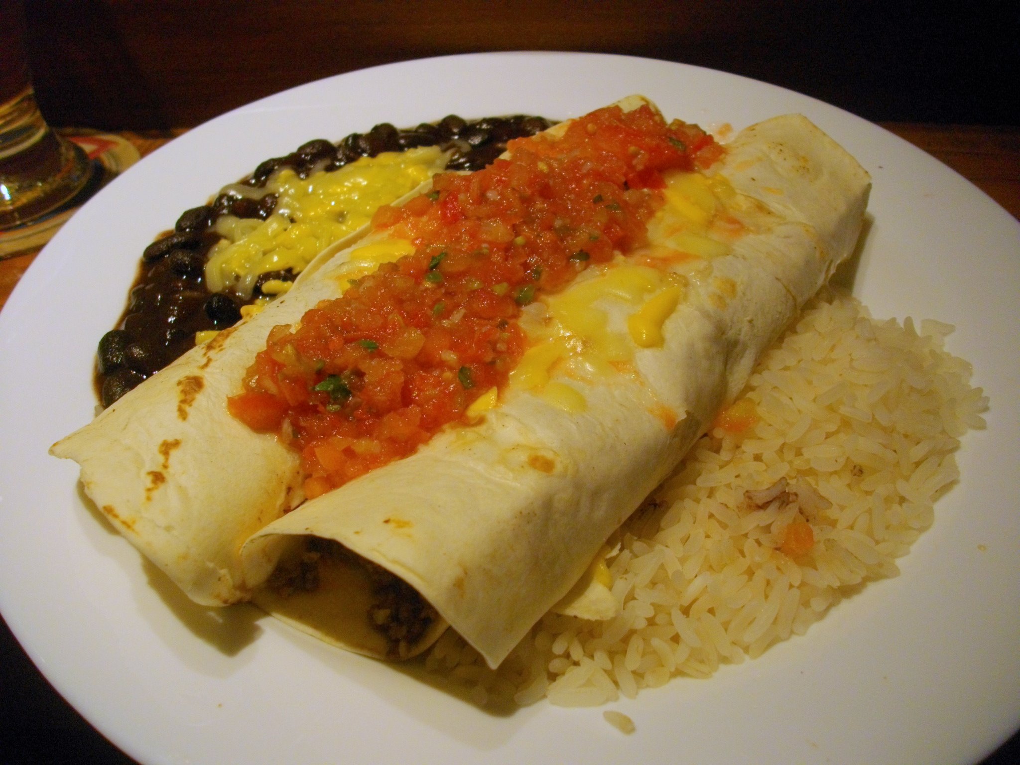 a close up of two burritos and rice