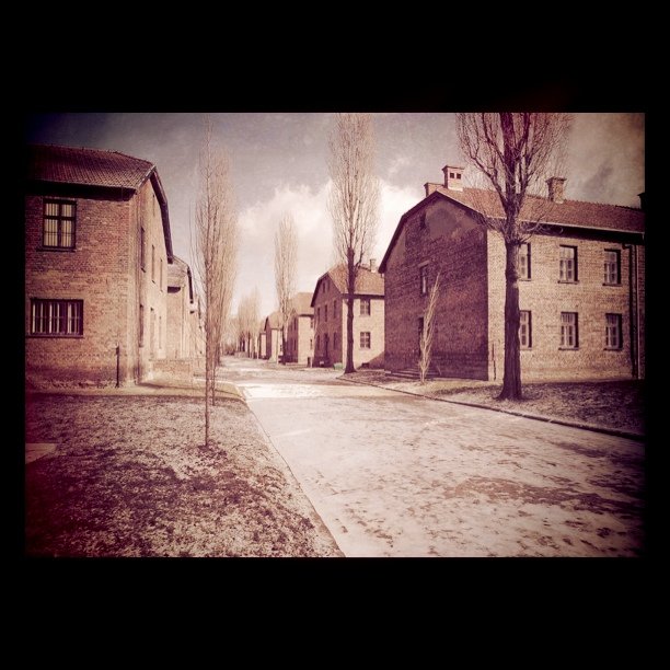 a dirt road near two buildings and a street sign