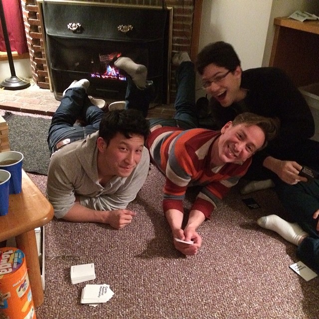 three men are on the floor looking at their remotes