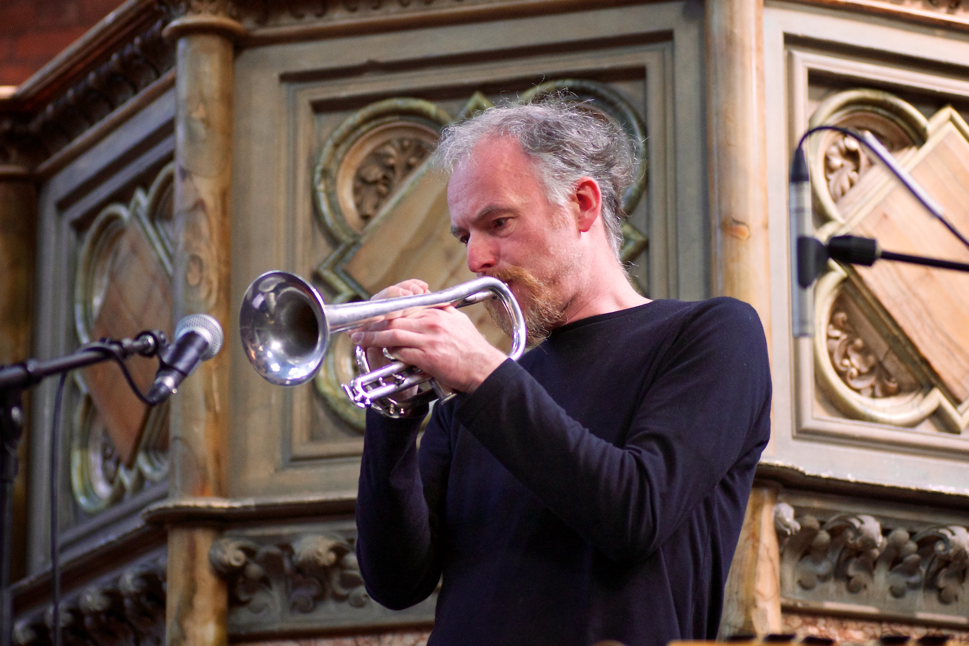 a man holding onto a trumpet to play music